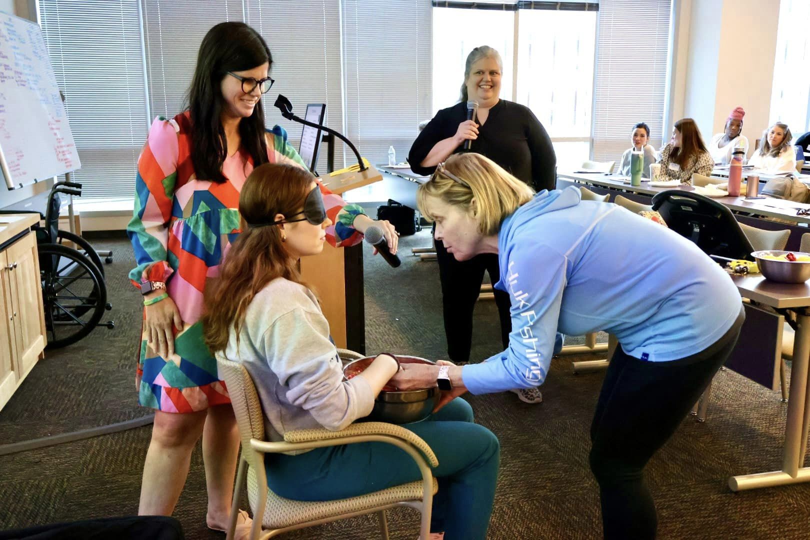 PD participants helps blindfolded person feel the contents of a bowl.