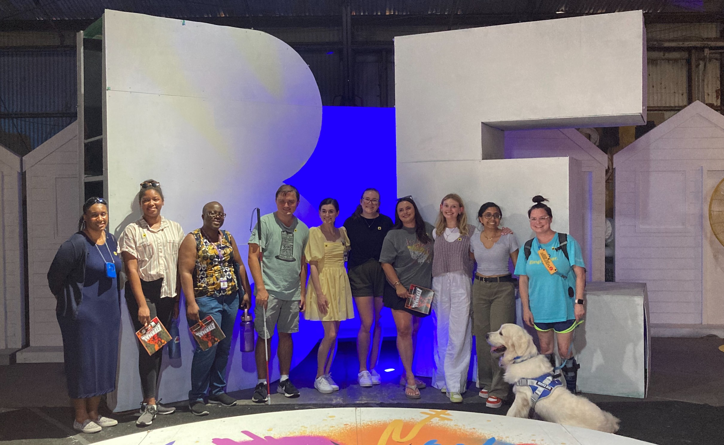 Group of LEND scholars at a museum stand smiling in front of giant letters that spell "Be"