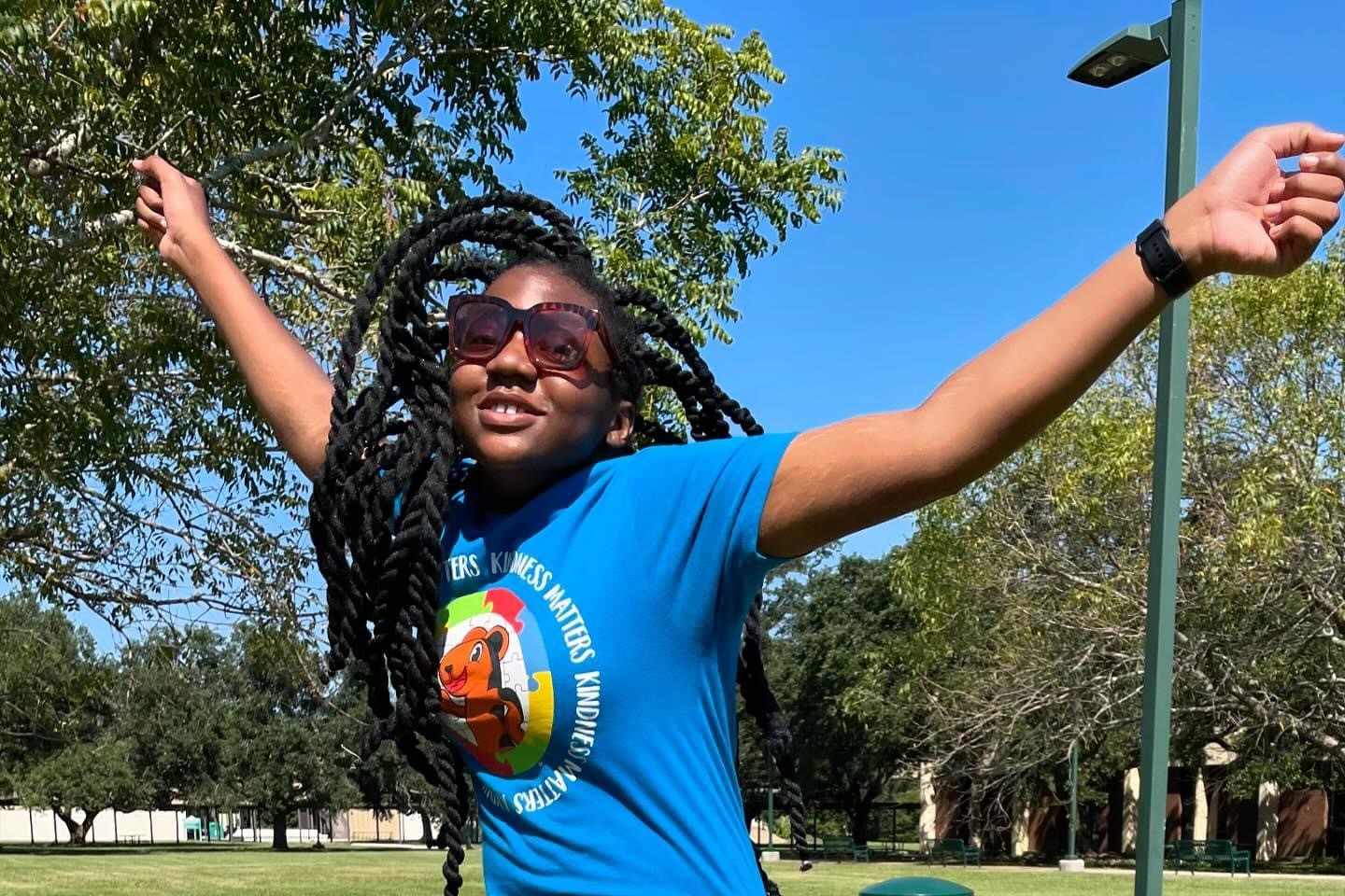 PAYCheck student jumps into the air while she's outside on Delgado's campus.