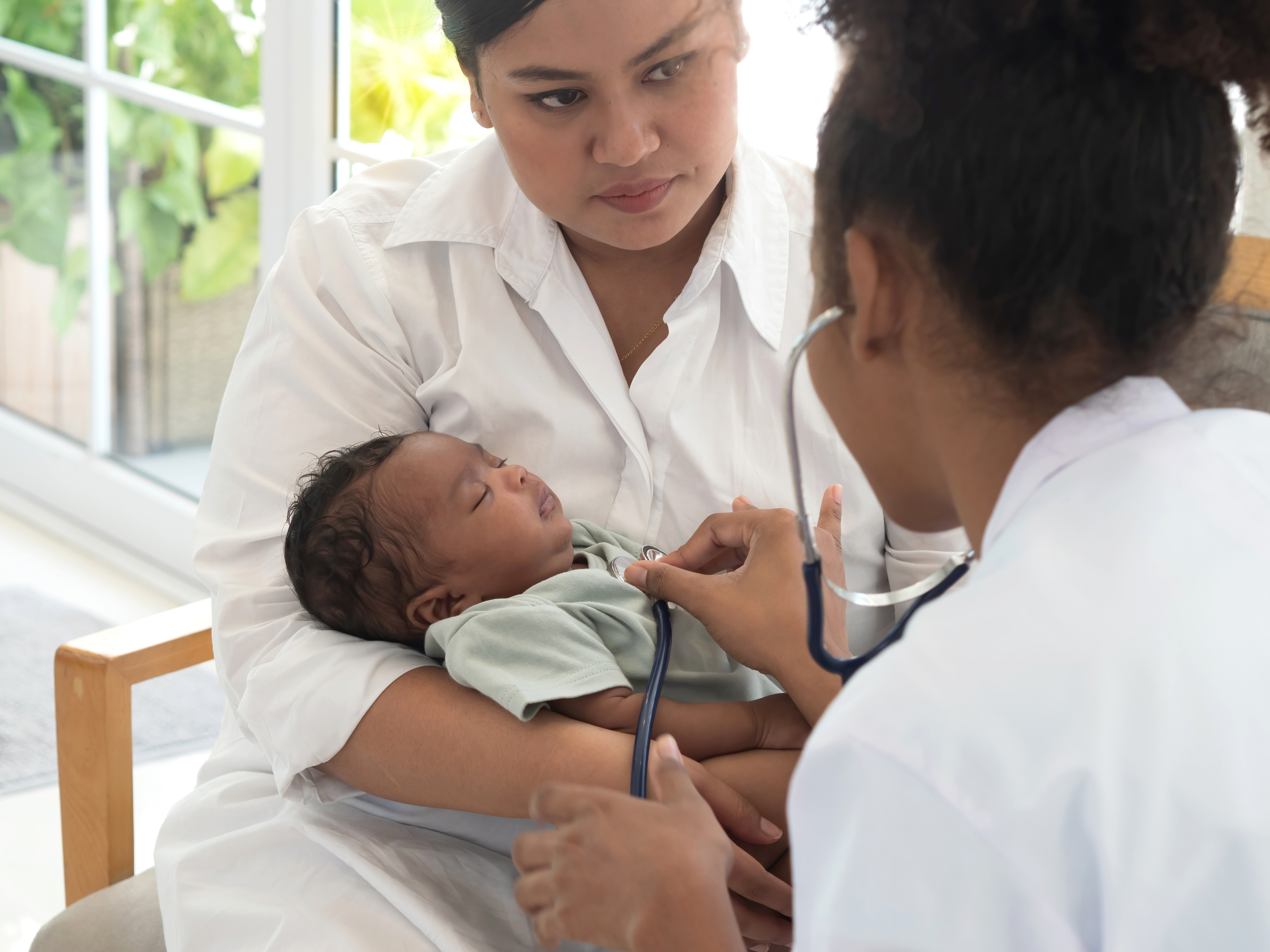 Nurse checks baby's heartbeat with a stethoscope.