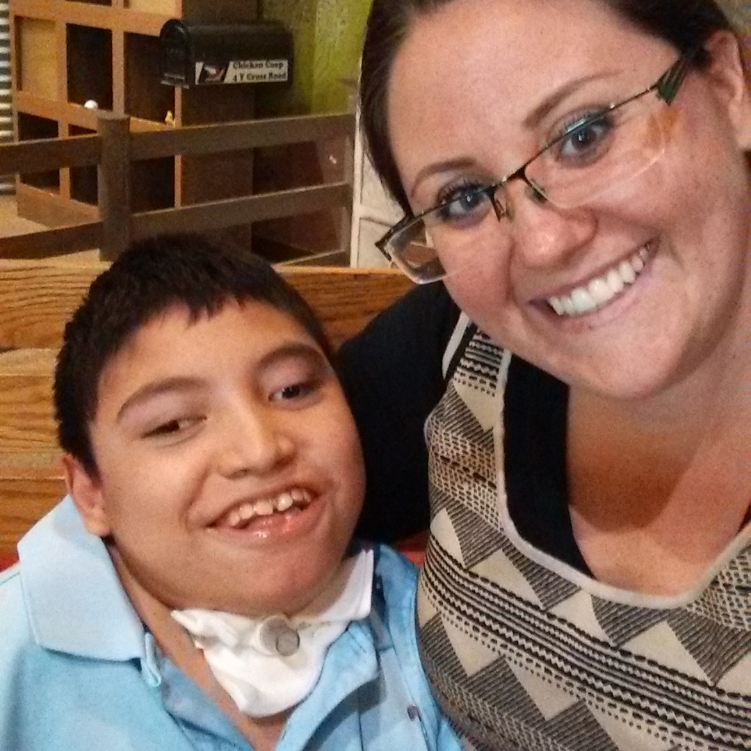 Mother and son smiling. Son has a Tracheostomy.