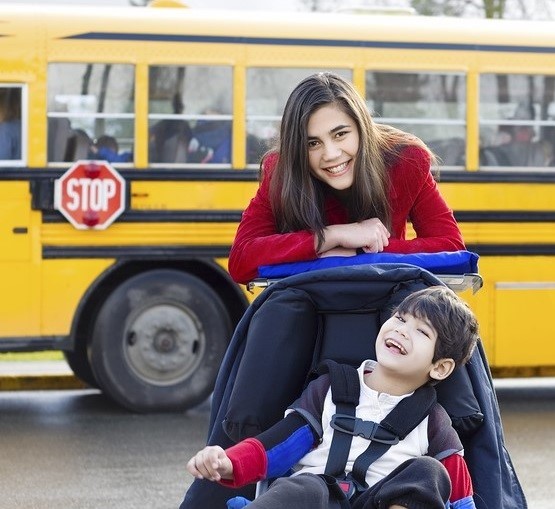 Child and parent in front of school bus