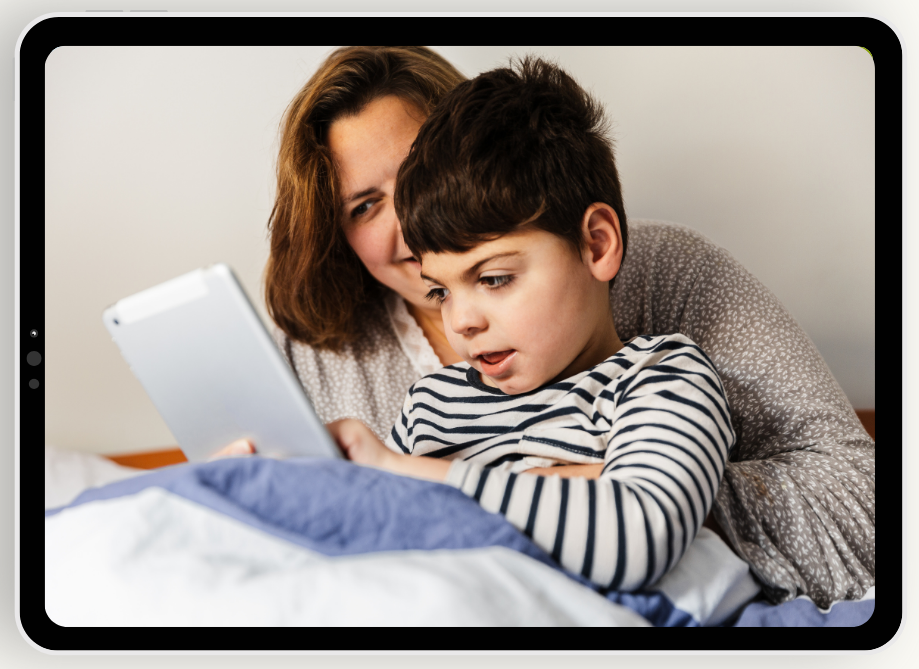 Boy looks at tablet with his mother.