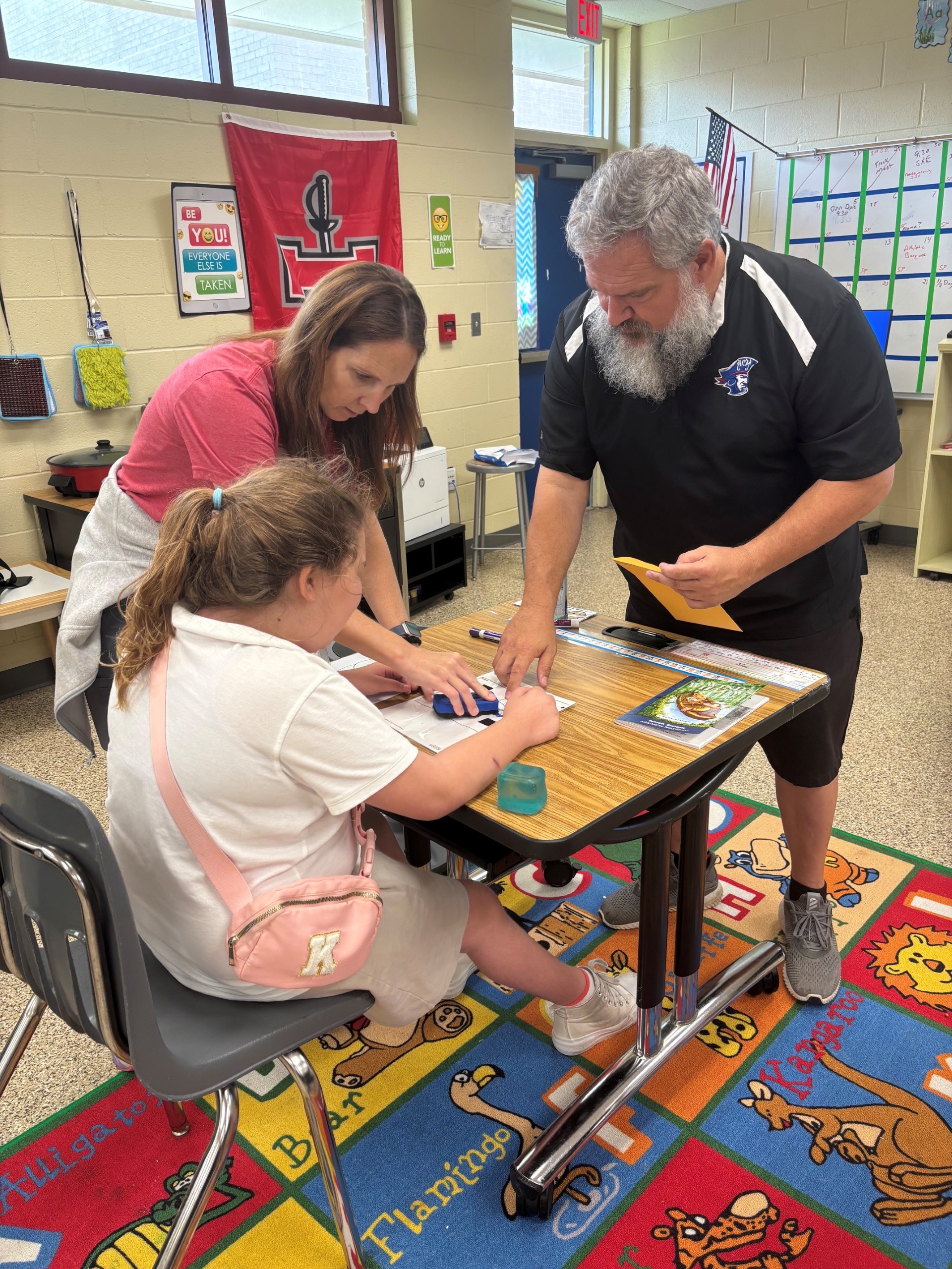 Teacher and para with student at desk