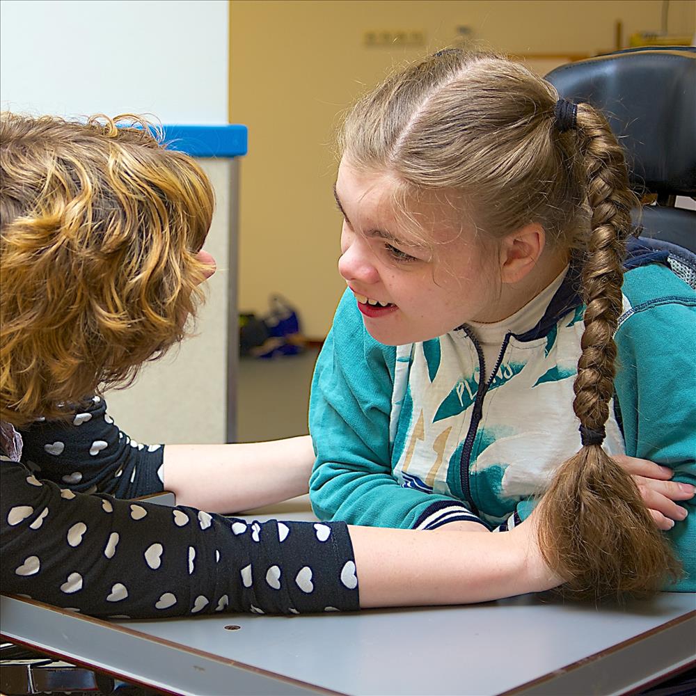 Disability: a disabled child smiling at the care assistant