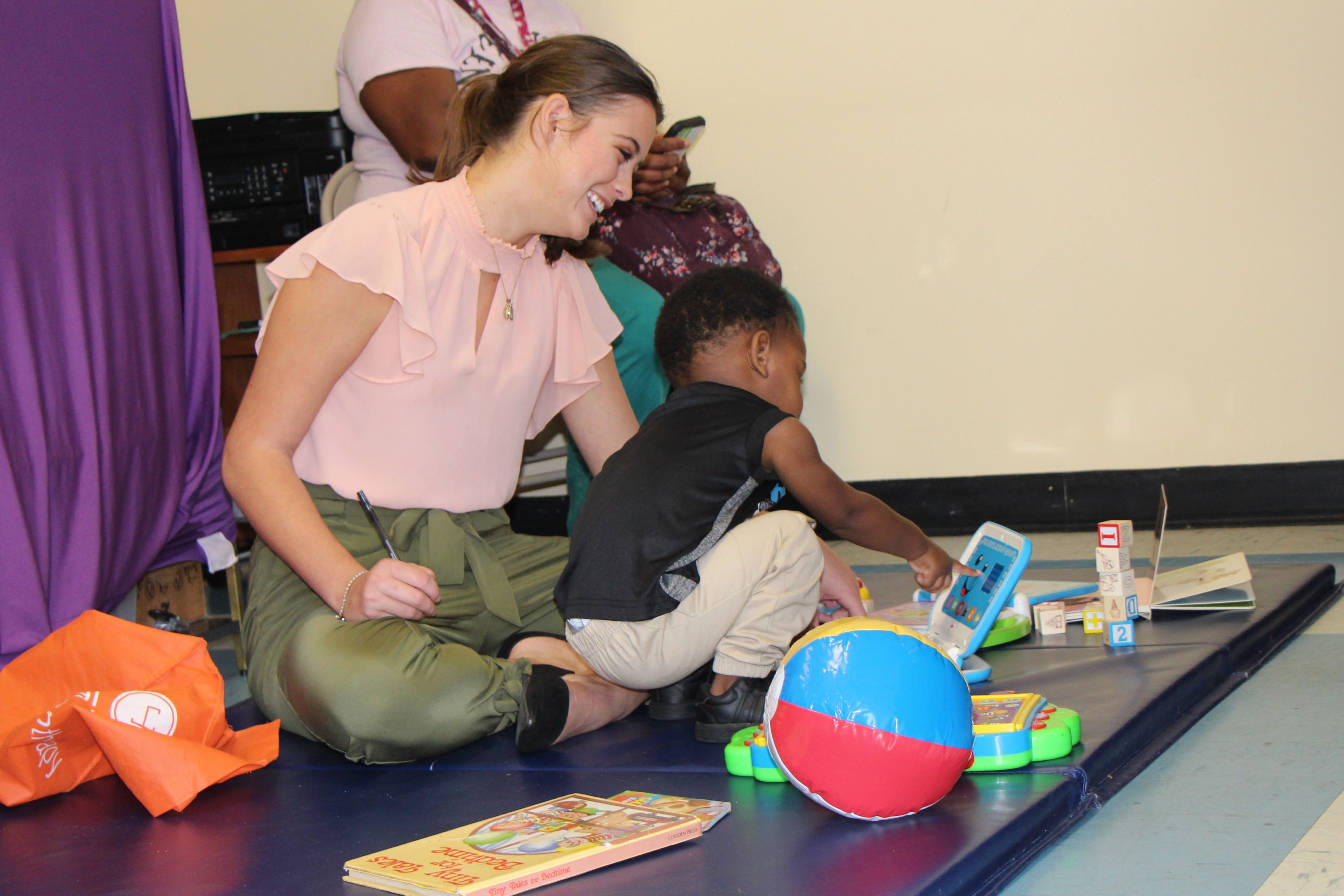 Scholar plays with toddler during evaluation.
