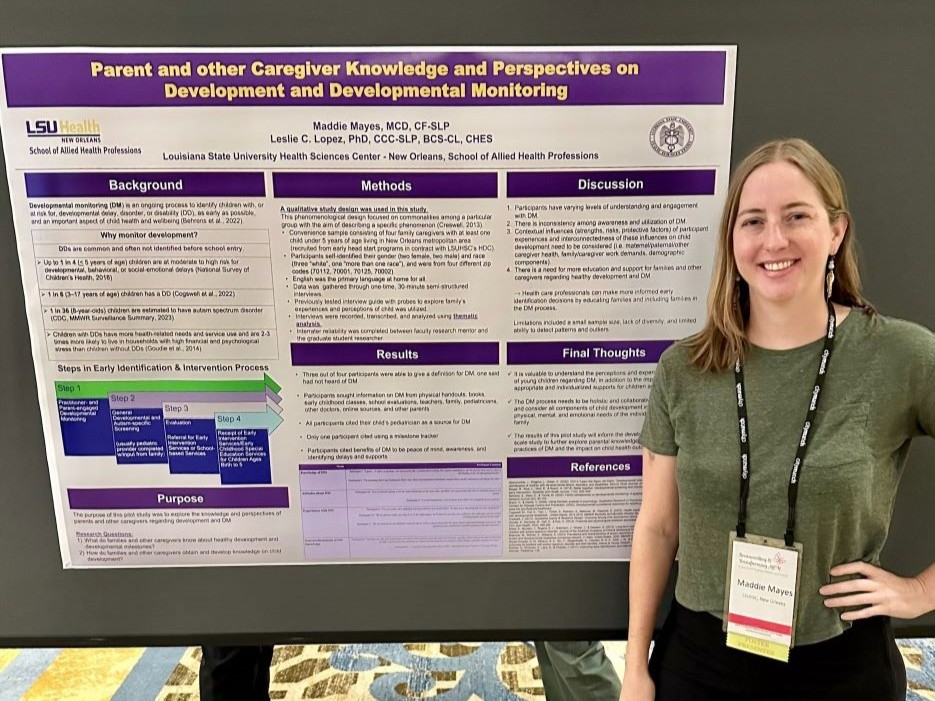 Scholar standing next to research poster.